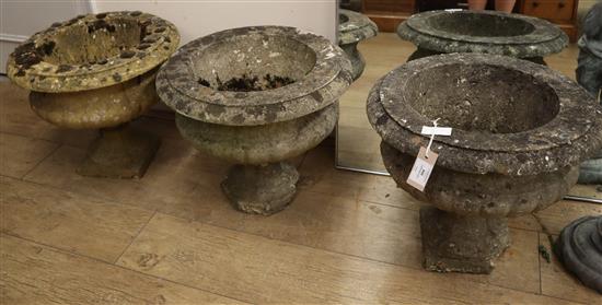 Three reconstituted stone garden urns on stands W.46cm